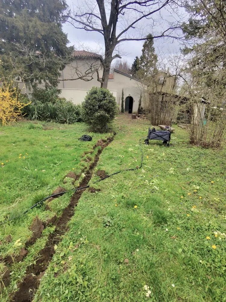 Préparation d’une tranchée et des liaisons techniques dans un jardin de particulier